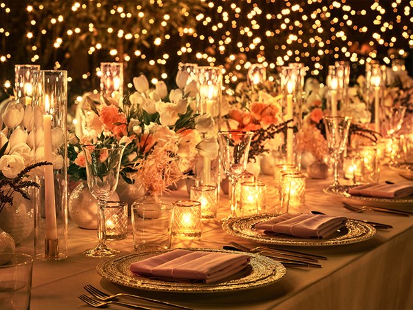 Candles and plates arranged on a table with a backdrop of fairylights in the Garden Terrace