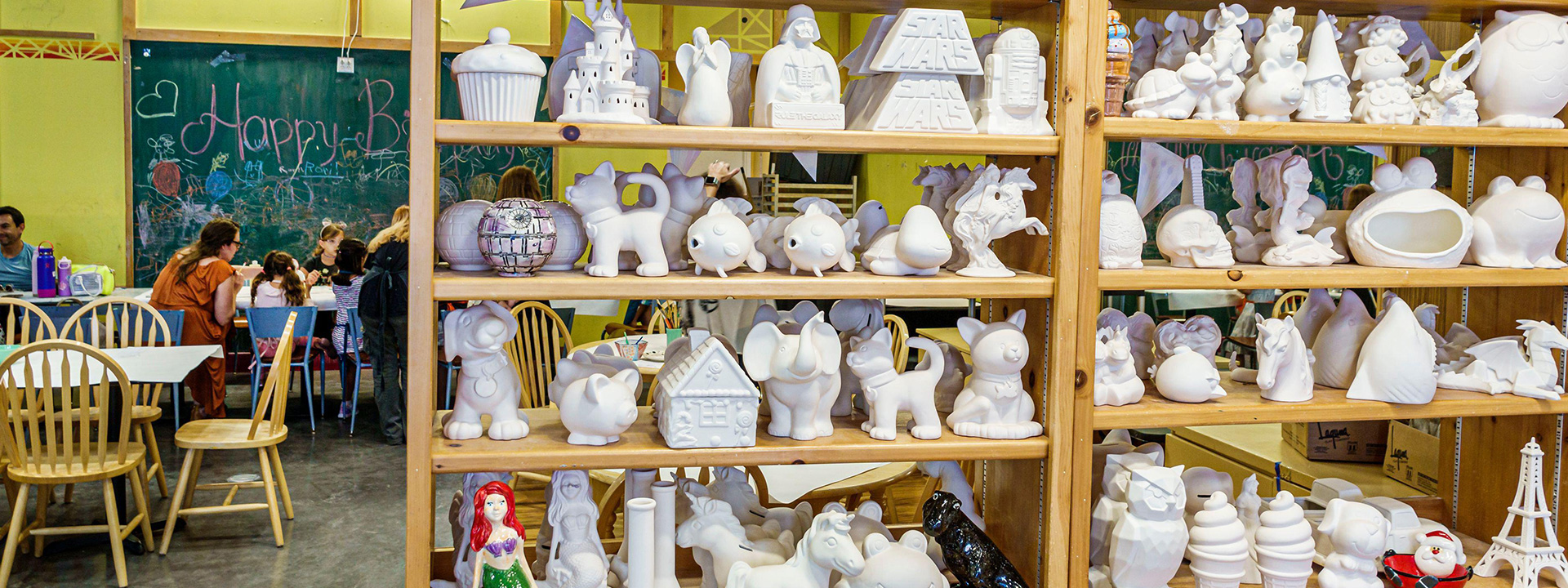 Shelves of pottery to be painted in pottery studio Colour Me Mine