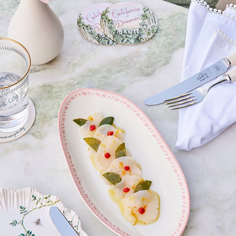 Ceviche placed on a white plate with small red garnishes