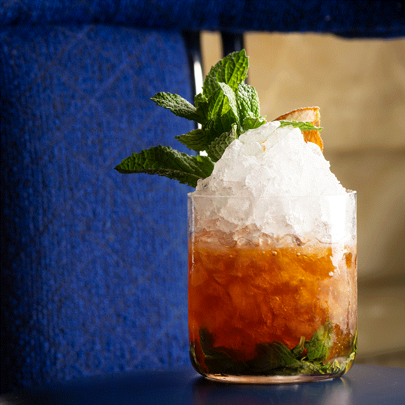 Cocktail in a short glass with muddled mint and crushed ice