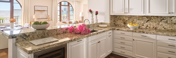 Kitchen area of the Three-bedroom Residence with a wine cooler, marble work tops and white cupboards