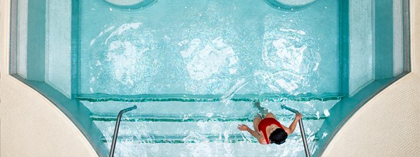 A woman stepping in the pool at The Maybourne Beverly Hills spa